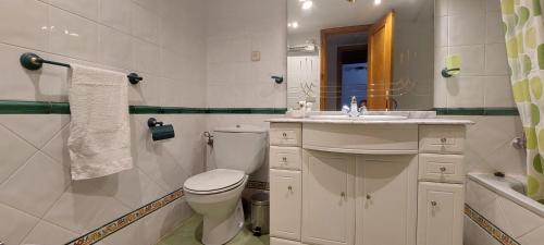 Un baño blanco con inodoro y lavabo. en La Casa de Su, en Baños de Montemayor