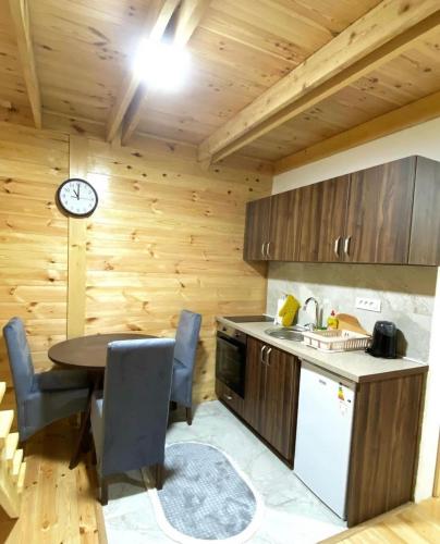 a kitchen with a table and a clock on the wall at Villa Wood Borje in Žabljak