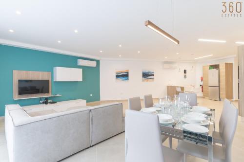 a dining room with a table and a tv at Stunning 3BR home in Gozo with access to pool by 360 Estates in Xagħra
