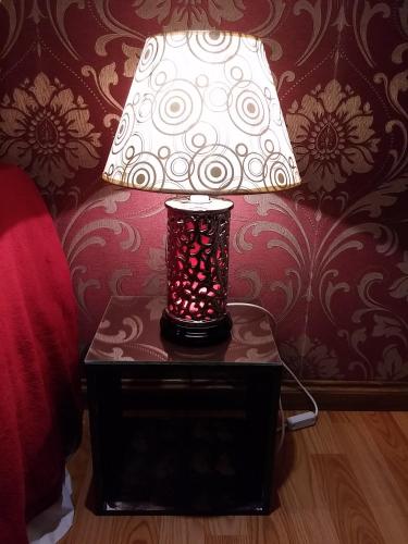 a lamp on a table next to a bed at Casa 24 Puerto Iguazu in Puerto Iguazú