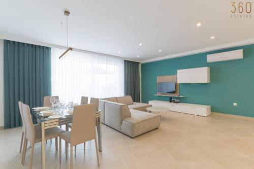 a dining room and living room with a table and chairs at Stunning 3BR home in Gozo with access to pool by 360 Estates in Xagħra