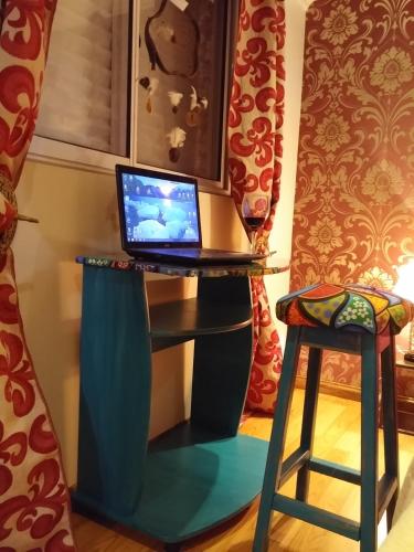 a laptop computer sitting on a desk with a stool at Casa 24 Puerto Iguazu in Puerto Iguazú