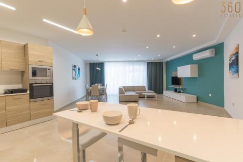 a kitchen and living room with a white table at Stunning 3BR home in Gozo with access to pool by 360 Estates in Xagħra