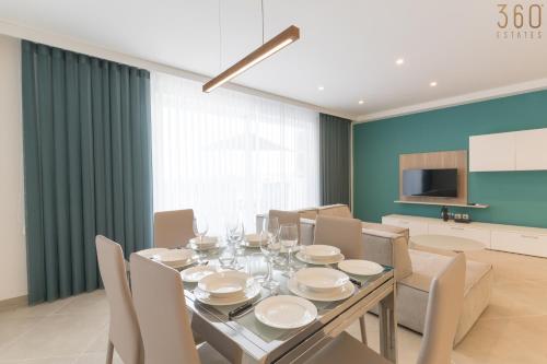a dining room with a dining table and chairs at Stunning 3BR home in Gozo with access to pool by 360 Estates in Xagħra
