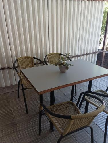 a table with two chairs and a potted plant on it at Alojamiento in Fray Bentos