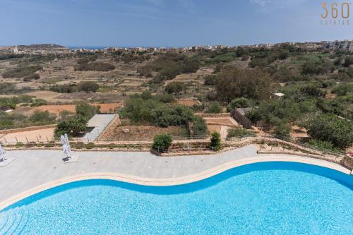 an aerial view of a swimming pool at a resort at Stunning 3BR home in Gozo with access to pool by 360 Estates in Xagħra