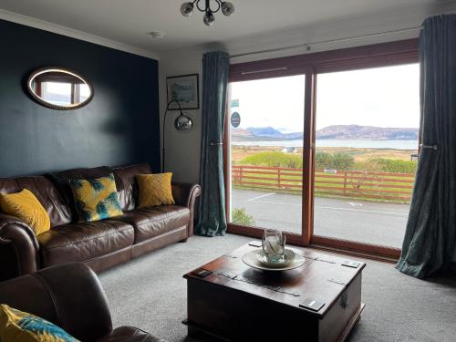 a living room with a couch and a large window at Ruisgarry Accommodation in Breakish