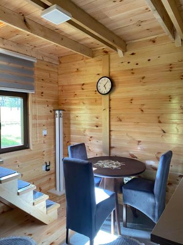 a room with a table and chairs and a clock at Villa Wood Borje in Žabljak