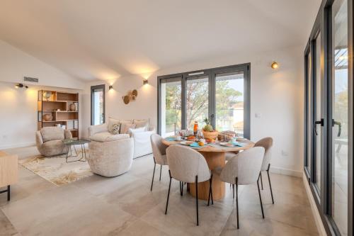 une salle à manger avec une table et des chaises dans l'établissement L'Ecrin 103 - Golfe de Saint-Tropez - Happy Rentals, à Sainte-Maxime