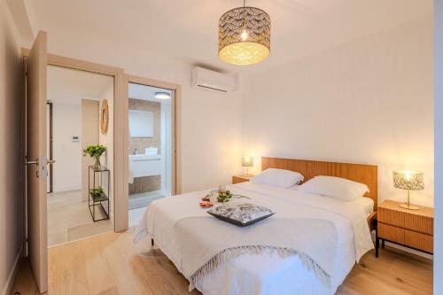 une chambre avec un grand lit blanc dans une pièce dans l'établissement L'Ecrin 103 - Golfe de Saint-Tropez - Happy Rentals, à Sainte-Maxime