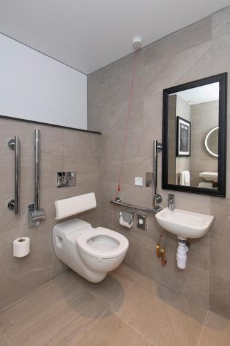 a bathroom with a toilet and a sink and a mirror at ibis Styles London Gatwick Airport in Crawley