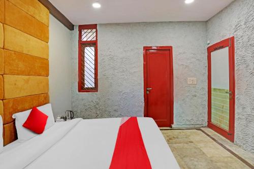 a bedroom with a bed with a red door at Flagship Kashish Residency in New Delhi