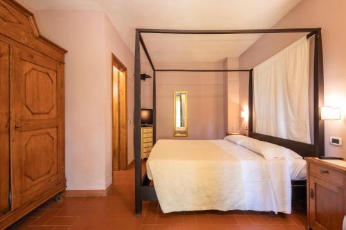 1 dormitorio con 1 cama con dosel en Relais Ciavatta Country Hotel, en Montemerano