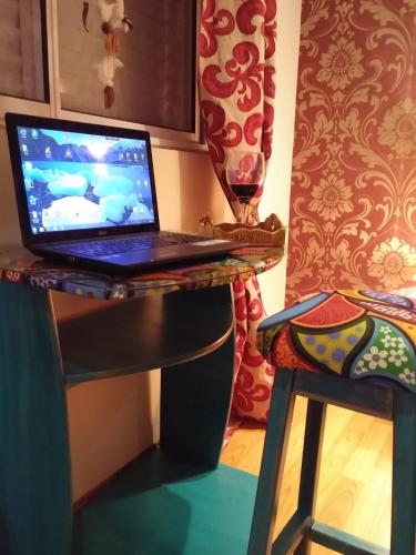 a laptop computer sitting on a desk with a stool at Casa 24 Puerto Iguazu in Puerto Iguazú