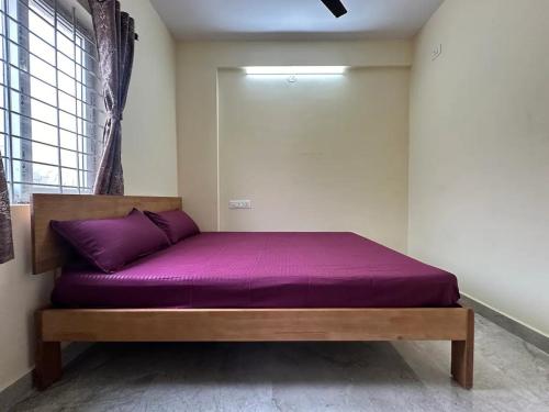 バンガロールにあるCozy Room 1Bhk with Lift 503の窓付きの部屋のベッド1台(紫のシーツ付)