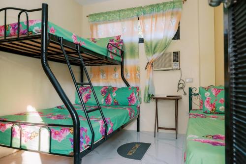 a bedroom with two bunk beds and a table at Villa Leonida Resort in Bugallon
