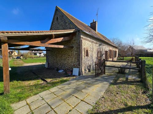 an old brick building with a wooden roof at Ancien gîte de chasse, calme & nature in Saint-Michel-Tubœuf