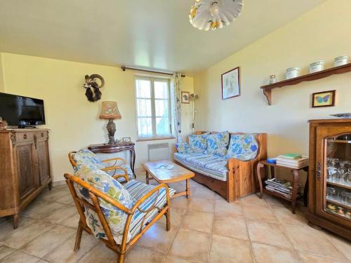 a living room with a couch and a tv at Ancien gîte de chasse, calme & nature in Saint-Michel-Tubœuf