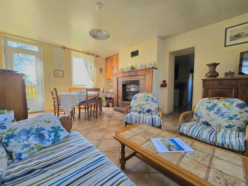 a living room with two couches and a table at Ancien gîte de chasse, calme & nature in Saint-Michel-Tubœuf