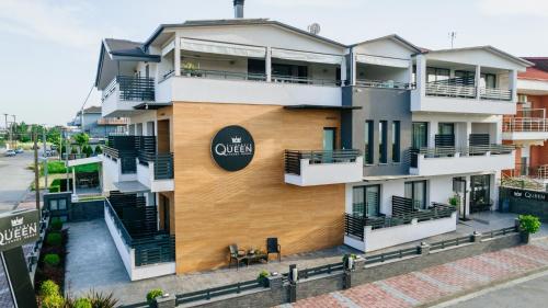 an apartment building with a sign on the side of it at Elizabeth Queen Luxury Rooms in Paralia Katerinis