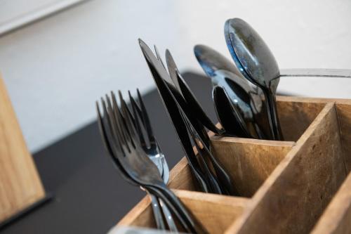 a wooden holder filled with forks and knives at Relax Apart Bonn in Bonn
