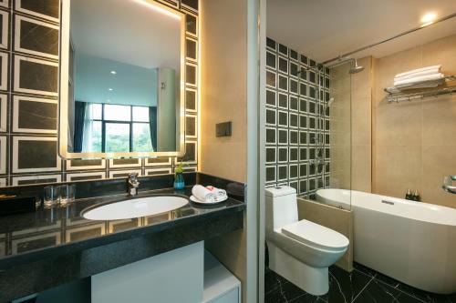 y baño con lavabo, aseo y bañera. en Ping Hotel, en Hanói