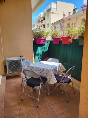 Appartement traversant et lumineux avec terrasse في سان لوران دو فار: طاولة وكراسي على شرفة مع نباتات الفخار