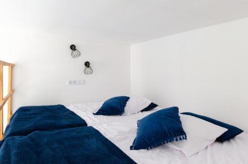 ein Bett mit blauen Kissen darüber in der Unterkunft Centrum 2 Struga 46 in Łódź