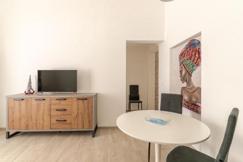 salon ze stołem i telewizorem w obiekcie La Casa di Nonna w mieście Ostuni
