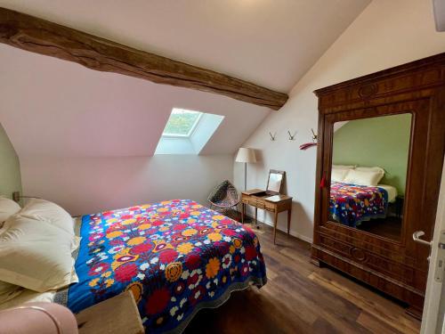 una camera da letto con un letto e uno specchio di La Petite Maison ad Auxey-Duresses