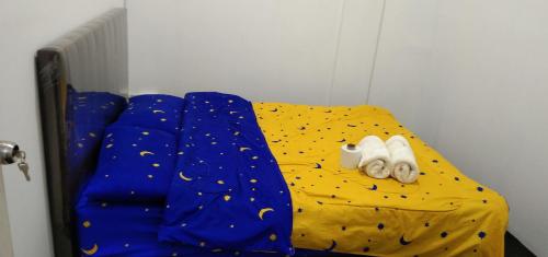 Ce lit se trouve dans un dortoir doté d'une couette jaune. dans l'établissement Melrose homestay and transport, à Bandar Seri Begawan