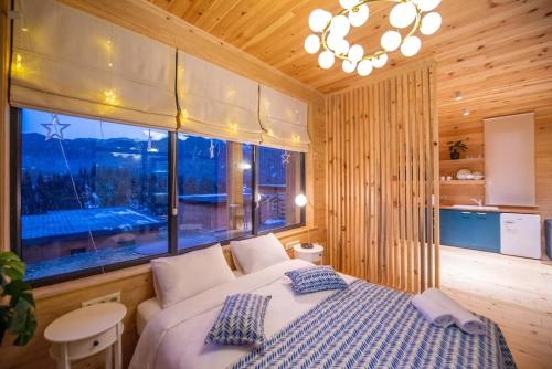 a bedroom with a bed and a large window at Mountain-view double villa, pet-friendly, ideal for long stays Svaneti Countryside 3 in Mestia