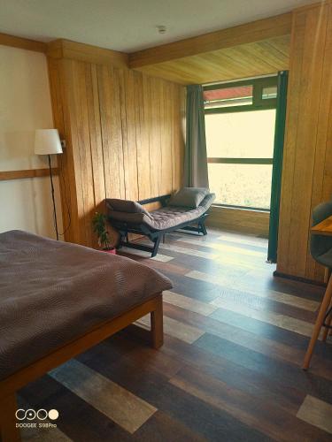 a room with a bed and a couch and a window at Casa Moroeni in Moroeni