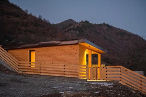 a small wooden cabin with a mountain in the background at Mountain-view double villa, pet-friendly, ideal for long stays Svaneti Countryside 3 in Mestia