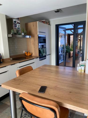 une cuisine avec une table et des chaises en bois dans l'établissement Un petit havre de paix, à Saint-Estève