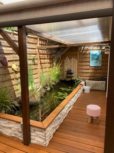 un étang à poissons dans une maison avec une terrasse dans l'établissement Un petit havre de paix, à Saint-Estève