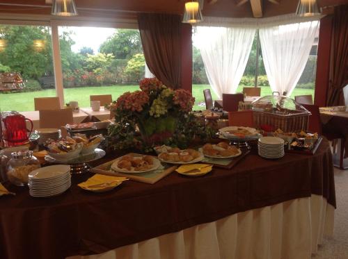 a table with plates of food on it at Relais Villa Annamaria Bed end Breakfast in Istrana