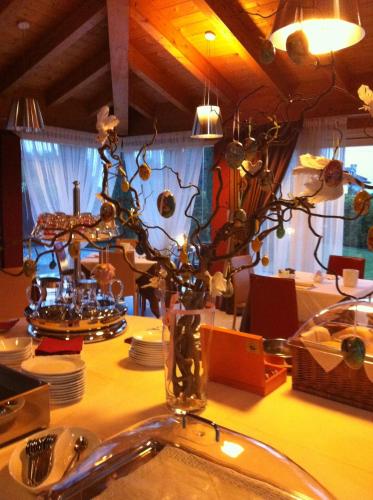 a table with plates and a vase with flowers on it at Relais Villa Annamaria Bed end Breakfast in Istrana