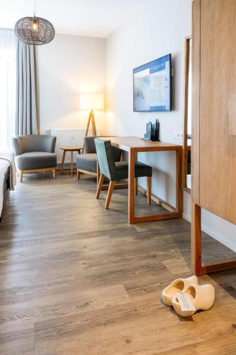 a living room with a desk and a table at Boutique Hotel Texel in De Cocksdorp