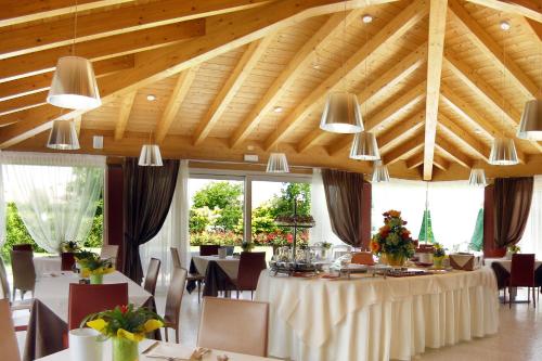 a dining room with tables and chairs and wooden ceilings at Relais Villa Annamaria Bed end Breakfast in Istrana