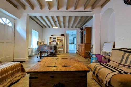 - un salon avec une table en bois dans l'établissement Maison de village - Jardin - 8 min de Center Parcs, à Chennebrun