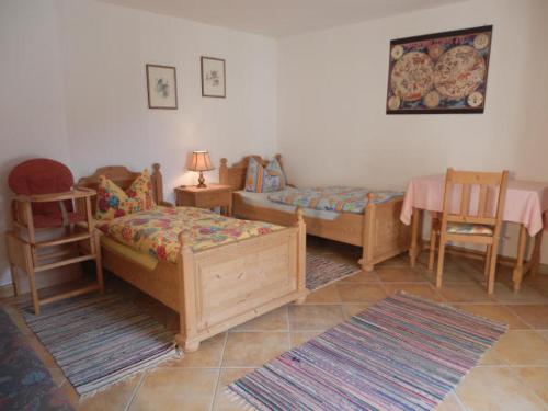 Un dormitorio con dos camas y una mesa y sillas. en Barmbichlhof, en Anger