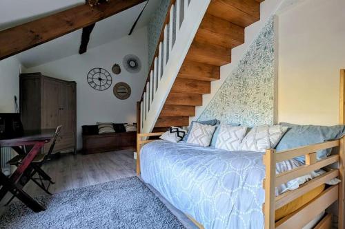 a bedroom with a bed and a staircase at Douceur de vivre au bord de l'Avre in Chennebrun