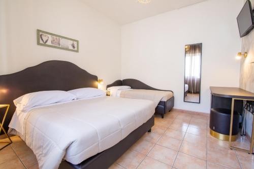 a hotel room with two beds and a table at Villa Liliana in Cervia