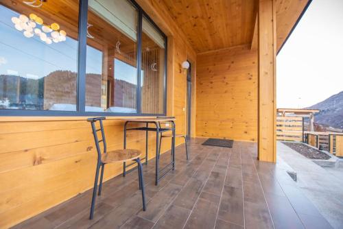 a room with two chairs and a table on a porch at Elegant pet-friendly double villa, perfect for couples Svaneti Countryside 4 in Mestia