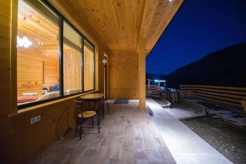 a wooden house with a balcony with a table and chairs at Elegant pet-friendly double villa, perfect for couples Svaneti Countryside 4 in Mestia