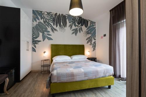 a bedroom with a bed with a green headboard at Villa Liliana in Cervia