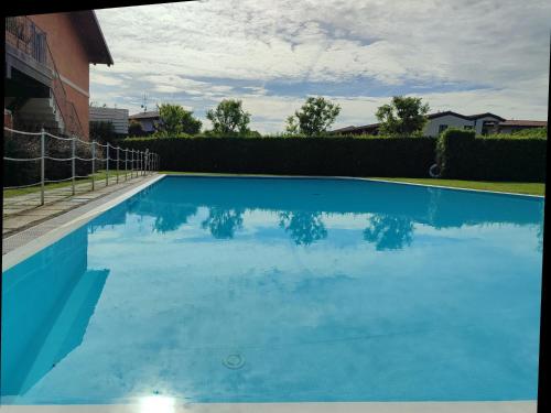 una piscina de agua azul en un patio en Casa degli Ulivi, en Padenghe sul Garda