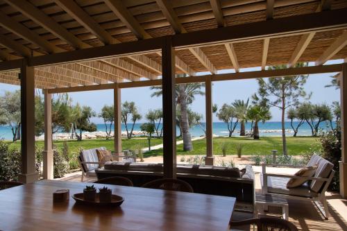 a view of the beach from the porch of a beach house at Elya Beach Luxury Suites in Ayios Theodhoros