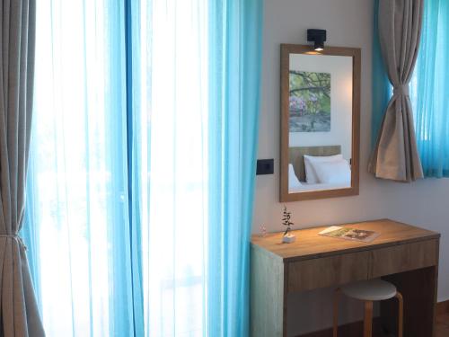 a bathroom with blue curtains and a table and a mirror at Chios Shallow Sea in Karfas